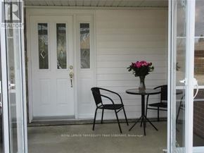 Brampton (Brampton East) apartment for rent - A white door with a glass panel and a flower vase on a table outside a house.
