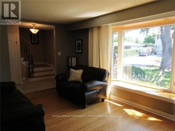 Brampton (Brampton East) apartment for rent - A living room with a black couch and a lamp.