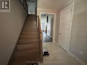 Milton (Walker) townhouse for rent - A staircase with a wooden banister and a white door at the top.