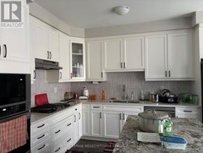 Milton (Walker) townhouse for rent - A kitchen with white cabinets and a granite countertop.