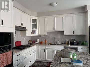 Milton (Walker) townhouse for rent - A kitchen with white cabinets and a granite countertop.