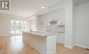 Oakville (Jm Joshua Meadows) townhouse for rent - A kitchen with white cabinets and a marble countertop.