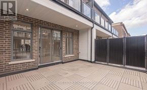 Oakville (Jm Joshua Meadows) townhouse for rent - A patio area of a building with a brick wall and a black fence.