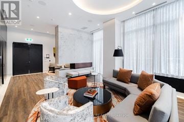 Toronto (Waterfront Communities) condo for rent - A modern living room with a grey sofa and a round coffee table.
