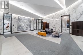 Toronto (Waterfront Communities) condo for rent - A spacious lobby with marble walls and floors, and a reception desk.