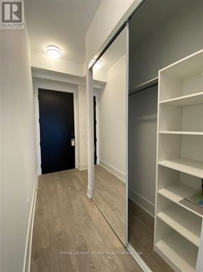 Toronto (Waterfront Communities) condo for rent - A hallway with a black door and white shelves on the right.