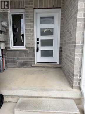 St. Marys townhouse for rent - A white door with a glass panel is on a brick wall.