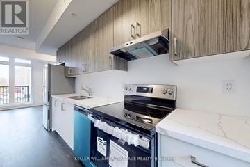 Ajax (Central) townhouse for rent - A modern kitchen with a stove top oven and a counter top.