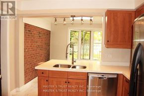 Oakville (Fd Ford) apartment for rent - A kitchen with wooden cabinets and a brick wall.