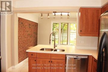 Oakville (Fd Ford) apartment for rent - A kitchen with wooden cabinets and a brick wall.