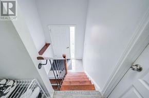 Oshawa (Farewell) apartment for rent - A staircase with a white door at the end.