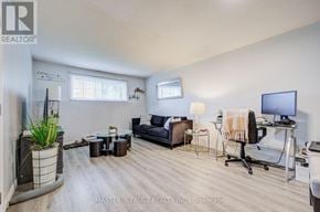 Oshawa (Farewell) apartment for rent - A well-lit living room with a couch, chair, and desk.