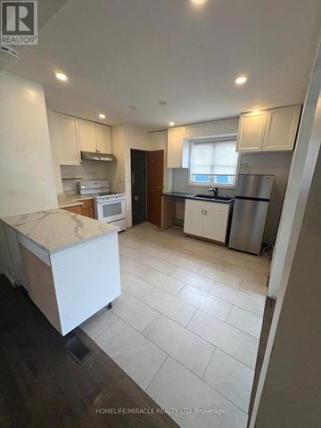 Oshawa (Central) apartment for rent - A kitchen with white appliances and cabinets.