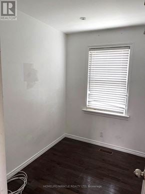 Oshawa (Central) apartment for rent - A room with a window and wooden floors.