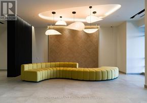 Brampton (Fletcher's Creek South) condo for rent - A modern reception area with a curved yellow bench and a wooden patterned wall.
