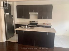 Brampton (Northwest Brampton) townhouse for rent - A kitchen with black cabinets and a stainless steel refrigerator.