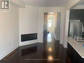 Brampton (Northwest Brampton) townhouse for rent - A spacious living room with a fireplace and wooden floors.