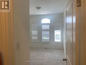 Brampton (Northwest Brampton) townhouse for rent - A room with a window and shutters, and a door on the right.