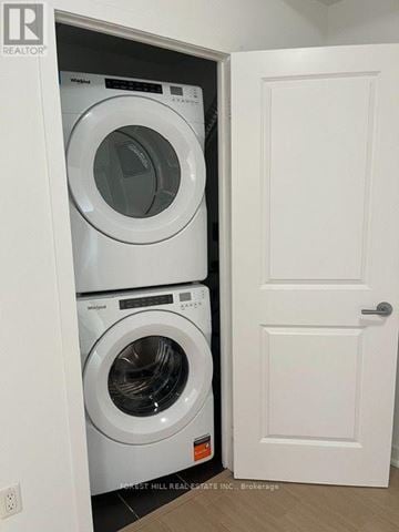 Toronto (Forest Hill South) house for rent - A white door is open to a small laundry room with a washer and dryer.
