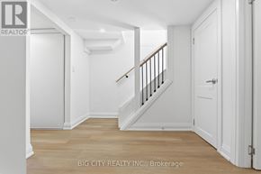 Oshawa (Vanier) multi-family for rent - A white hallway with a wooden staircase and white walls.