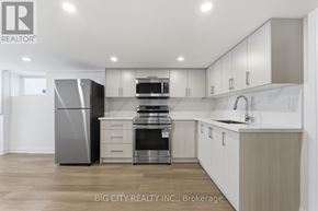 Oshawa (Vanier) multi-family for rent - A modern kitchen with a refrigerator, microwave, and oven.