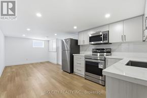 Oshawa (Vanier) multi-family for rent - A modern kitchen with stainless steel appliances and white cabinets.