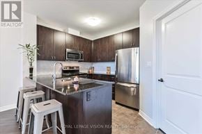 Markham (Middlefield) condo for rent - A kitchen with a refrigerator, microwave, and stove top oven.
