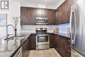 Markham (Middlefield) condo for rent - A kitchen with a stove top oven and a microwave above it.