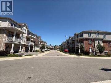 Kitchener townhouse for rent - A street view of a residential area with apartment buildings on both sides.
