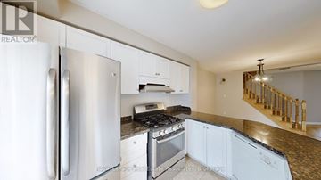 Mississauga (Lisgar) apartment for rent - A kitchen with a stainless steel refrigerator and a stove top oven.