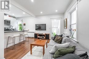 Toronto (Roncesvalles) duplex for rent - A modern living room with a wooden floor and white walls.