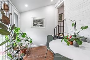 Toronto (Roncesvalles) duplex for rent - A white dining table with a green chair and a potted plant on it.