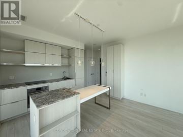 Toronto (Church-Yonge Corridor) condo for rent - A modern kitchen with white cabinets and a granite countertop.