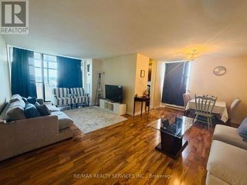 Brampton (Queen Street Corridor) condo for rent - A living room with a couch, chairs, and a television.
