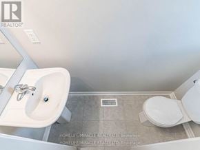Hamilton (Ryckmans) townhouse for rent - A bathroom with a sink, toilet, and a wall-mounted mirror.