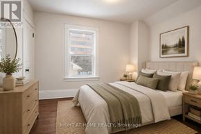 Kitchener multi-family for rent - A well-lit bedroom with a large bed, a nightstand, and a window.