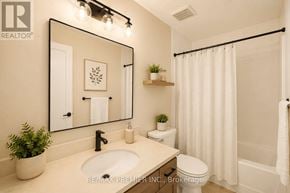 Waterloo townhouse for rent - A bathroom with a sink, toilet, and a mirror.