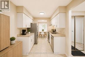 Waterloo townhouse for rent - A modern kitchen with white cabinets and a wooden island.