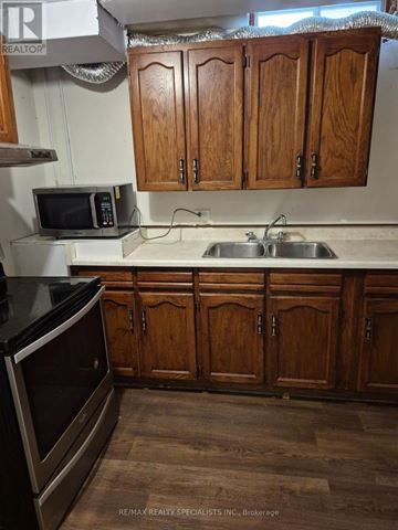 Vaughan (Brownridge) apartment for rent - A kitchen with wooden cabinets and a black counter top.