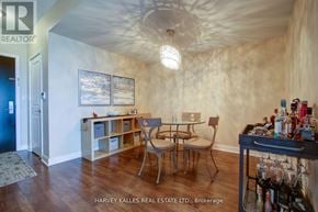 Mississauga (City Centre) condo for rent - A dining room with a table and chairs and a cabinet with shelves.