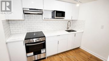 Toronto (Keelesdale-Eglinton West) apartment for rent - A white kitchen with a stove and microwave.