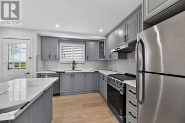 Woodstock (Woodstock - North) apartment for rent - A modern kitchen with a stainless steel refrigerator and wooden floors.