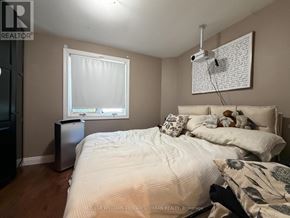 Toronto (Trinity-Bellwoods) apartment for rent - A bedroom with a bed, nightstand, and window.