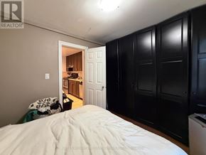 Toronto (Trinity-Bellwoods) apartment for rent - A bedroom with a bed in the foreground and a kitchen area visible through the open door.
