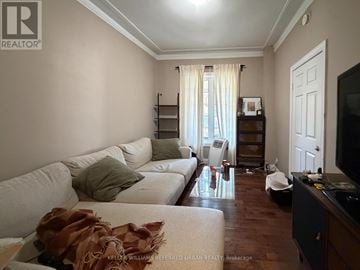 Toronto (Trinity-Bellwoods) apartment for rent - A living room with a white couch and a brown throw on it.