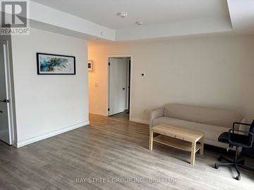 Toronto (Junction Area) condo for rent - A living room with a couch, coffee table, and a painting on the wall.