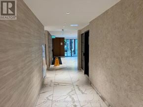 Toronto (Junction Area) condo for rent - A hallway with a marble floor and walls, leading to a door with a sign that says "REALTOR".