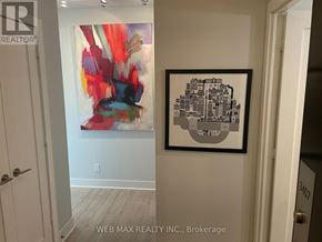 Toronto (North St. James Town) condo for rent - A hallway with a framed picture of a cityscape on the wall.