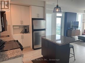 Toronto (North St. James Town) condo for rent - A kitchen with granite countertops and stainless steel appliances.