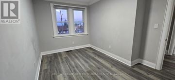 Oshawa (Vanier) apartment for rent - A room with a window showing a view of a street with houses and cars.